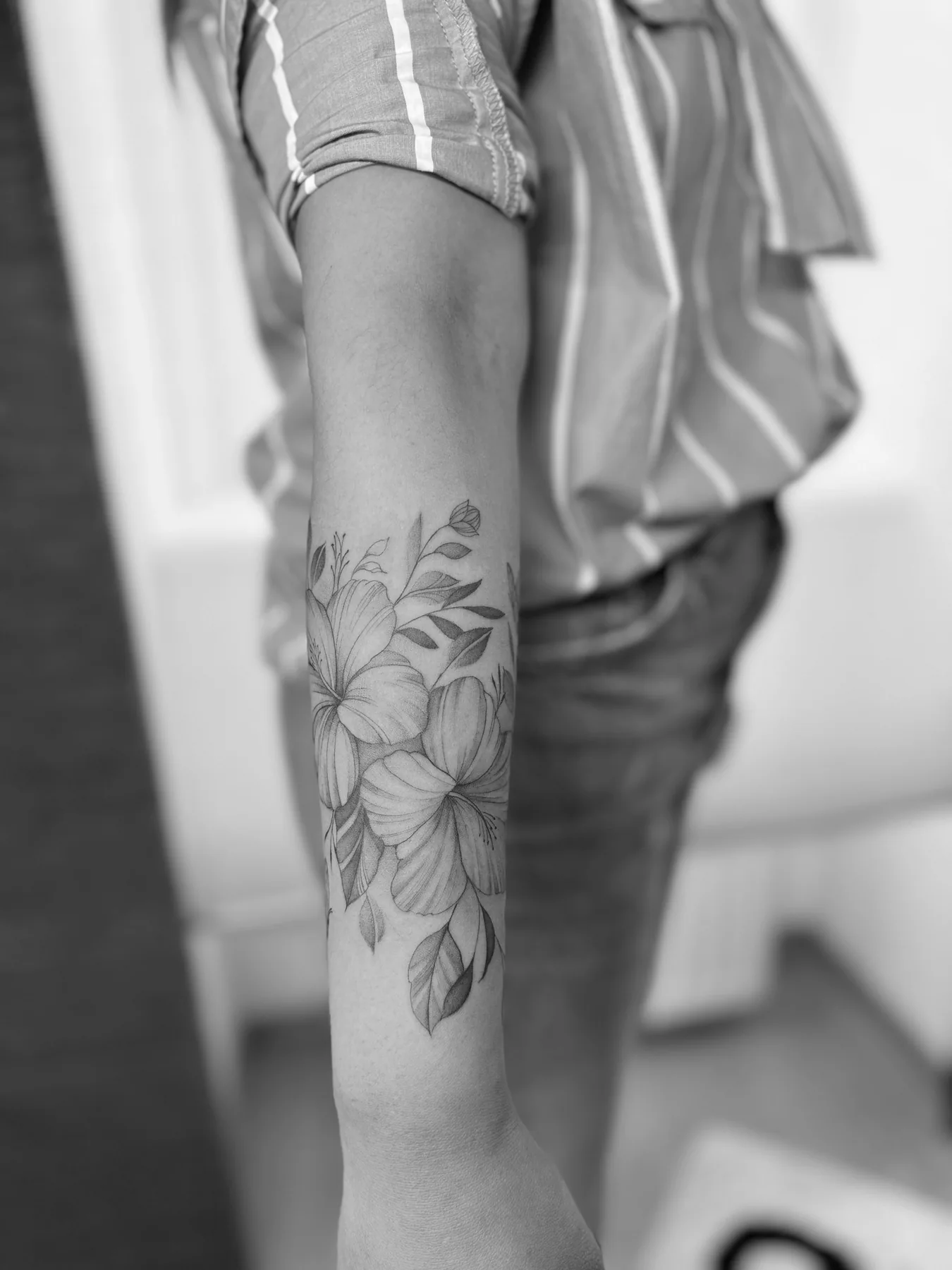 Feine Blüten und Blätter entlang eines Unterarms