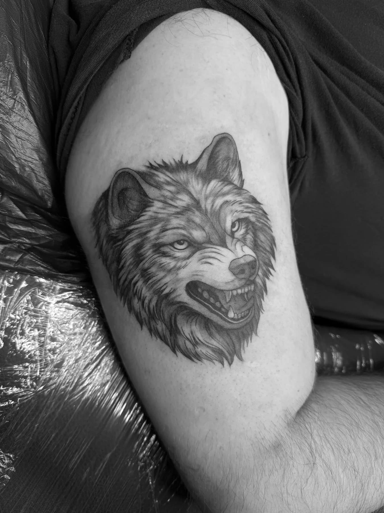 Wolfskopf mit lebendiger Fellzeichnung auf dem Oberarm