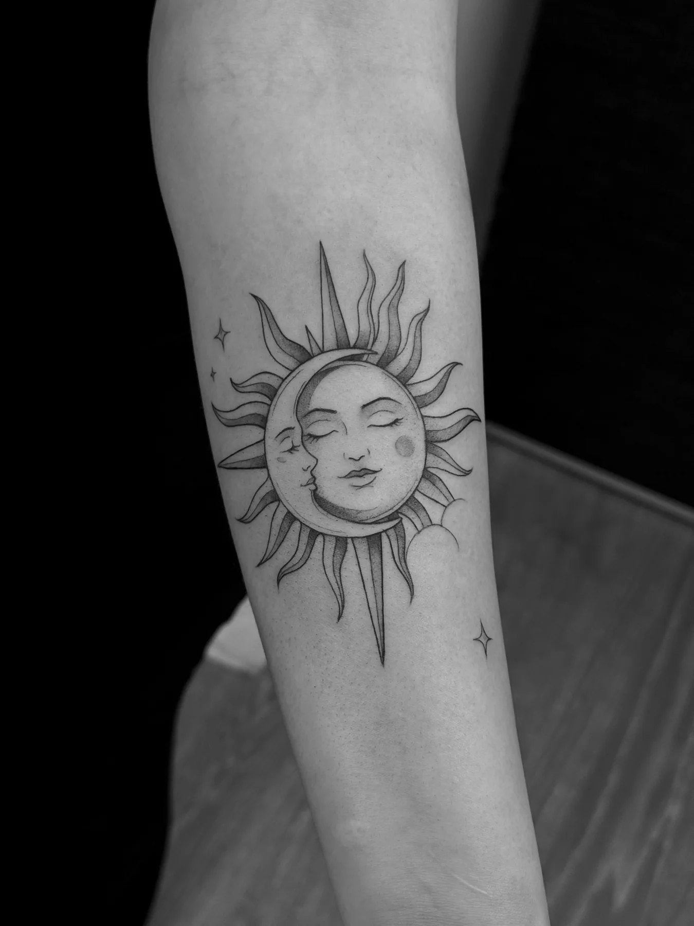Filigrane Sonne mit einem Gesicht auf dem Unterarm